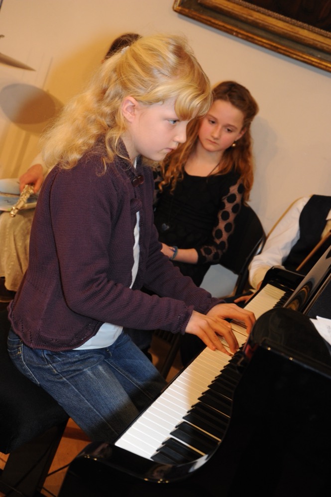 Dos alumnas tocan el piano a cuatro manos